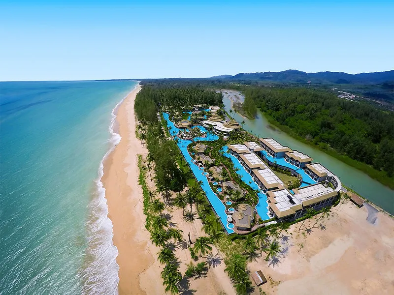 Zračni posnetek resorta The Haven z ogromnim modrim bazenom ob plaži
